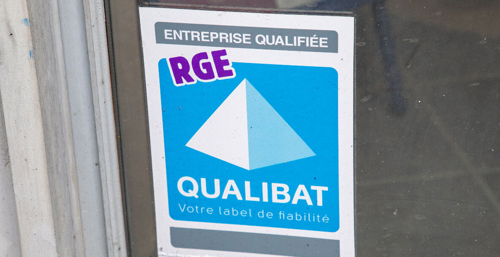 Artisan consultant sur tablette l'annuaire France Rénov pour vérifier certification RGE avant démarrage chantier isolation